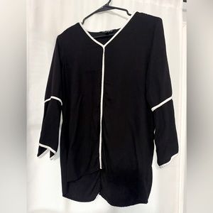 Beautiful black shirt with white piping. Slit arms for a chic look.